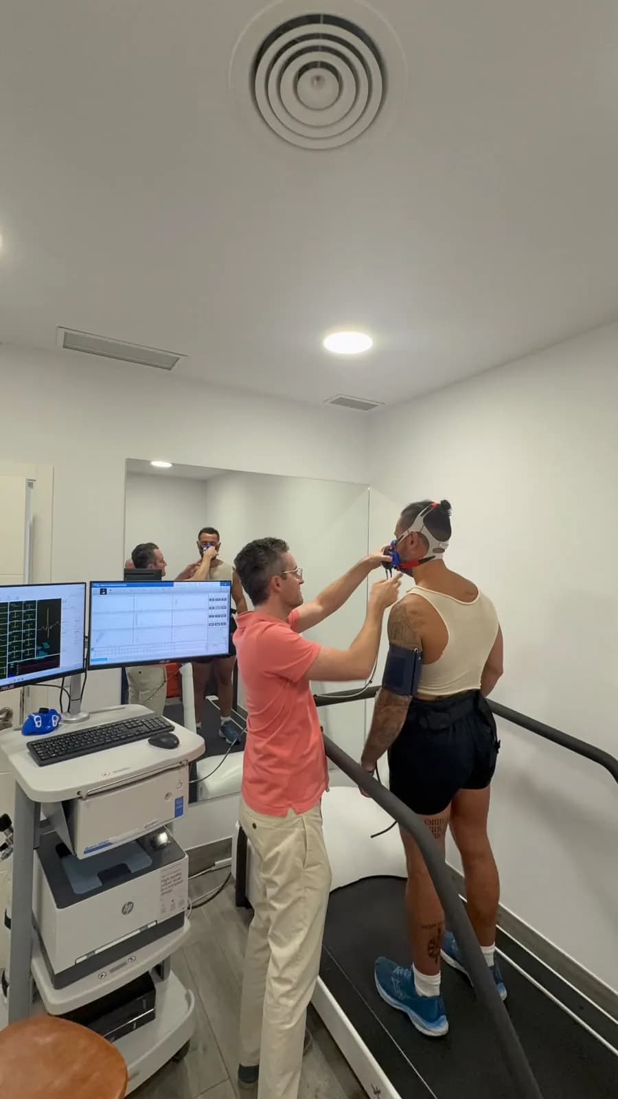 Cardiólogo colocando la mascarilla de análisis de gases a un paciente antes de la prueba de esfuerzo